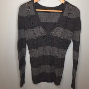 Grey V-neck cable knit sweater.